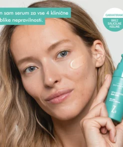 Ženska drži Novexpert Trio-Zinc Booster Serum, namenjen negi kože z nepravilnostmi.